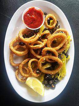 Product: Tender rings of calamari lightly breaded, flash fried and sauteed with hot peppers, black olives and fresh garlic. Served with side of marinara sauce.16.95 - Nikolas Pizza in Newport, RI Pizza Restaurant