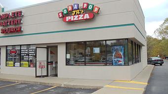 Exterior - Soda-Pop Jr's Pizza in Between Hertz Rent-a-Car and Woodland Lake Motel - Brighton, MI Pizza Restaurant