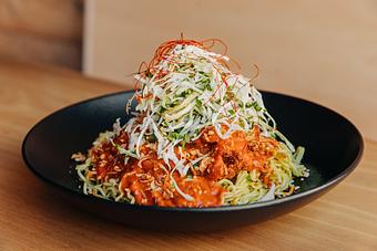 Product: featuring our guest chef, Zubair of Lilac Tiger. This dish uses our Tokyo wavy noodles and our popular karaage nuggets sauced with a fragrant spiced tomato sauce, topped with shredded cabbage, green onions, chopped herbs and fried shallot and garlic. - Ramen San in Chicago, IL Restaurants/Food & Dining