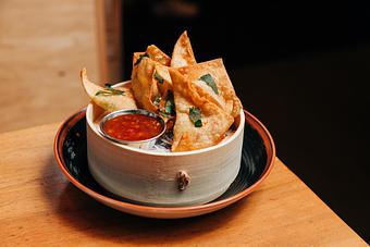 Product: seven crispy fried wontons stuffed with a creamy crab filling. served with housemade sweet chili sauce - RAMEN-SAN Whisky Bar in Fulton Market - Chicago, IL Japanese Restaurants