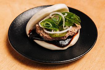Product: ground beef, pho spices, shaved onion salad and hoisin-sriracha sauce on a steamed bun - RAMEN-SAN Whisky Bar in Fulton Market - Chicago, IL Japanese Restaurants