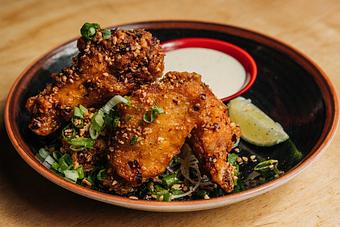 Product: five crispy chicken wings are tossed in a housemade spicy sesame chili sauce. served with fried garlic, pickled japanese daikon radish and lime kosho mayo - RAMEN-SAN Whisky Bar in Fulton Market - Chicago, IL Japanese Restaurants