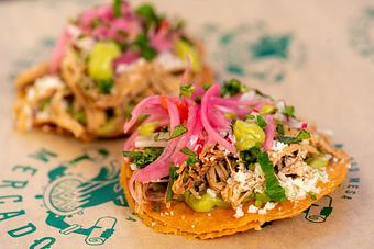 Product: TWO CRISPY TORTILLAS, PULLED PORK, AVOCADO SAUCE, GRILLED PINEAPPLE, PICKLED RED ONIONS, QUESO FRESCO, CILANTRO. - Red Mesa Mercado in St. Petersburg, FL Mexican Restaurants