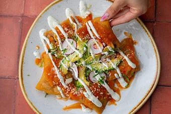 Product: OAXACA CHEESE AND CHORIZO STUFFED CHILAQUILES, SALSA TATEMADA, CILANTRO, QUESO FRESCO, CREMA AND RADISH. - Red Mesa Restaurant in St Petersburg, FL Mexican Restaurants