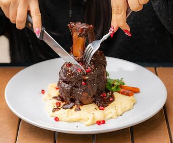 Product: PORK OSSOBUCO, MOLE COLORADITO, ROMANO CHEESE POLENTA, ROASTED CARROTS, POMEGRANATE SEEDS. - Red Mesa Restaurant in St Petersburg, FL Mexican Restaurants