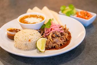 Product: Shredded carnitas, ancho tomatillo, pickled red onion, pico de gallo, guacamole. Cilantro rice & refried beans. Tortillas available upon request. (MGF) - Red Mesa Restaurant in St Petersburg, FL Mexican Restaurants