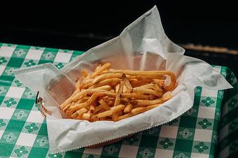 Product: a basket of thinly cut french fries in a basket with white parchment paper - RJ Grunts in Lincoln Park - Chicago, IL American Restaurants