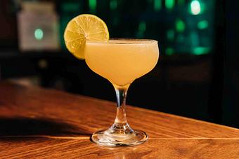 Product: An orange cocktail served in a martini glass, garnished with a slice of lime - RJ Grunts in Lincoln Park - Chicago, IL American Restaurants