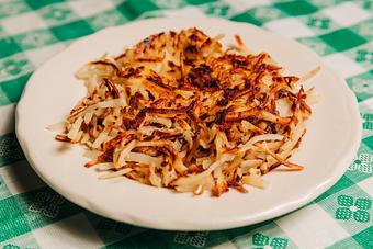 Product: A plate of crispy, shredded hash browns served on a white plate atop a green checkered tablecloth - RJ Grunts in Lincoln Park - Chicago, IL American Restaurants