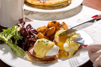 Product: Eggs Benedict with hollandaise and NY ham on a toasted English muffin. - Roxy Bar in TriBeCa - New York, NY Bars & Grills