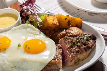 Product: NY Steak and Eggs with NY strip, fried organic egg, crispy herbed potatoes and sauce béarnaise. - Roxy Bar in TriBeCa - New York, NY Bars & Grills