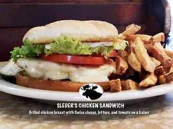 Product: Chicken Sandwich: grilled chicken breast with Swiss cheese, lettuce, and tomato on a Kaiser bun - Sleder's Family Tavern in Traverse City's Famous Slabtown! - Traverse City, MI American Restaurants