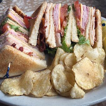 Product: Club Sandwich: ham, turkey, bacon, cheese, lettuce, tomato, and mayonnaise - Sleder's Family Tavern in Traverse City's Famous Slabtown! - Traverse City, MI American Restaurants