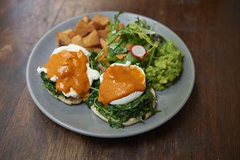 Product: two poached eggs, english muffin, piquillo sauce, patatas bravas, market greens - Socarrat Paella Bar - Chelsea in Chelsea - New York, NY Spanish Restaurants