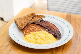 Product: Scrambled eggs served with a hash brown patty, bacon, and whole wheat toast - Summer House - Las Vegas in Las Vegas, NV Restaurants/Food & Dining
