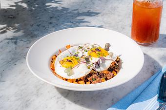 Product: Cubed potatoes topped with sunny side eggs, caramelized onions - Summer House - Las Vegas in Las Vegas, NV Restaurants/Food & Dining