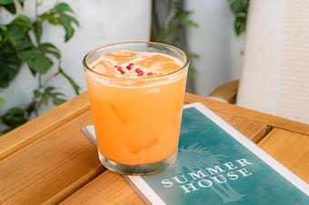 Product: Peach colored cocktail in a short glass of 818 blanco, passionfruit, and orgeat topped with pink peppercorn - Summer House - Las Vegas in Las Vegas, NV Restaurants/Food & Dining