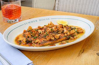 Product: A large, flat fillet of Idaho trout is pan-seared to a golden brown and rests in a pool of rich, amber-colored brown butter sauce. - Summer House - Las Vegas in Las Vegas, NV Restaurants/Food & Dining