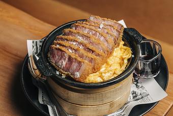 Product: 24 hour sous vide sakura pork is breaded with panko and fried. this crispy, tender, flavorful cut lays atop sushi rice and egg in a cast iron bowl. finished with tare. - Sushi San - Reservations in River North - Chicago, IL Japanese Restaurants