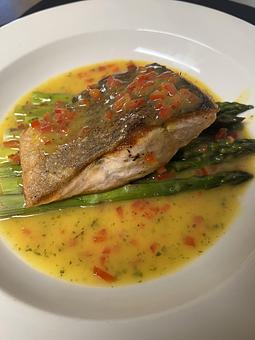 Product: Grilled Atlantic salmon in a light, citrusy orange sauce with asparagus and red pepper. - The Bowman in Parkville, MD American Restaurants