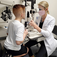 Doctor performing an eye exam on a young boy at True Eye Experts Lutz. - Photos of Our Business -  True Eye Experts of Lutz