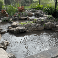 Backyard pond under construction with stone edging