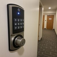 Florence Locksmiths installing a digital electronic keypad door lock for secure apartment building access. Call Us (859) 217-6974