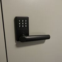 Georgetown Locksmiths installing a matte black digital keypad door lever lock for keyless access control. Call Us (737) 324-6433