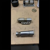 Disassembled lock components and latch cylinder hardware on a workbench by Fishkill Locksmith. Call Us (845) 599-0885